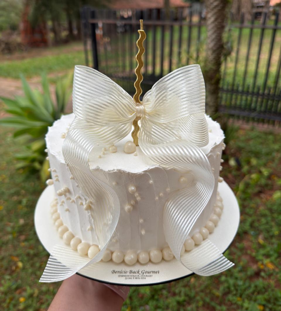Bolo branco elegante com laço de fita branca e pérolas